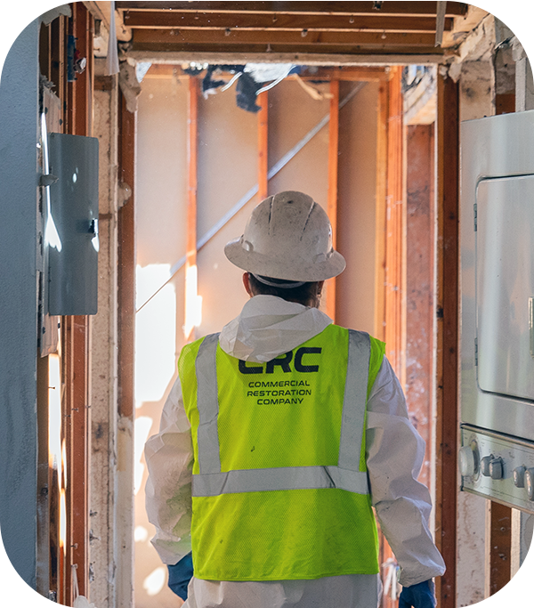 CRC worker walking through fire-damaged apartment building.