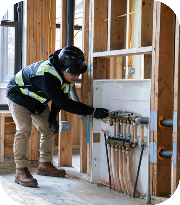 CRC worker adjusts water valves in construction area.