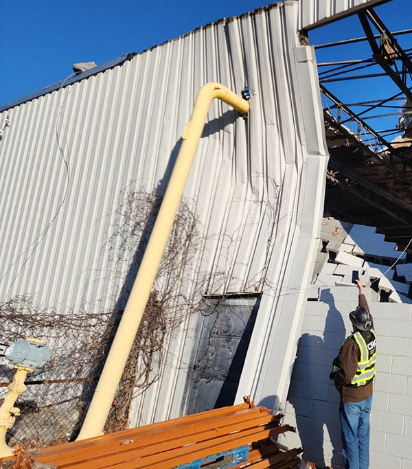 CRC-employee-assess-tornado-damage-to-manufacturing-warehouse.
