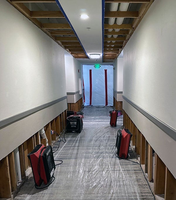Drying equipment in hotel hallway after pipes burst.