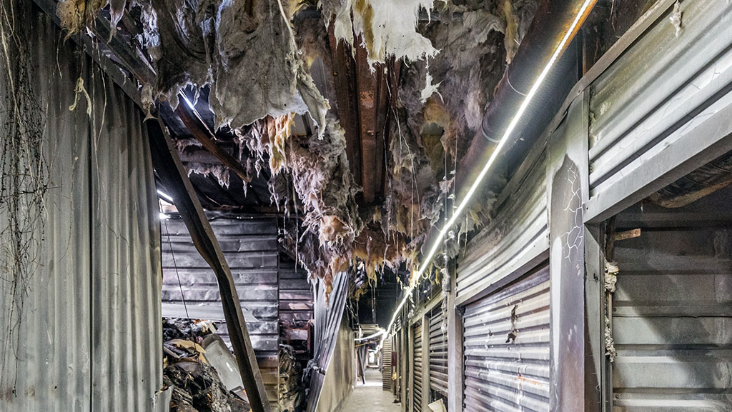 Fire-damaged storage facility with ceiling material coming down.