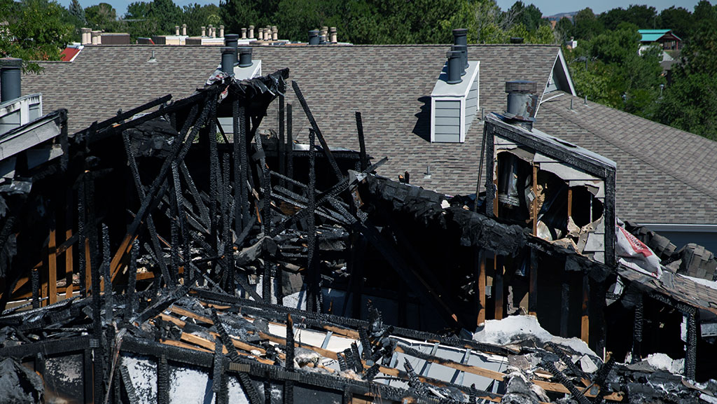 Apartment building roof damaged by fire.