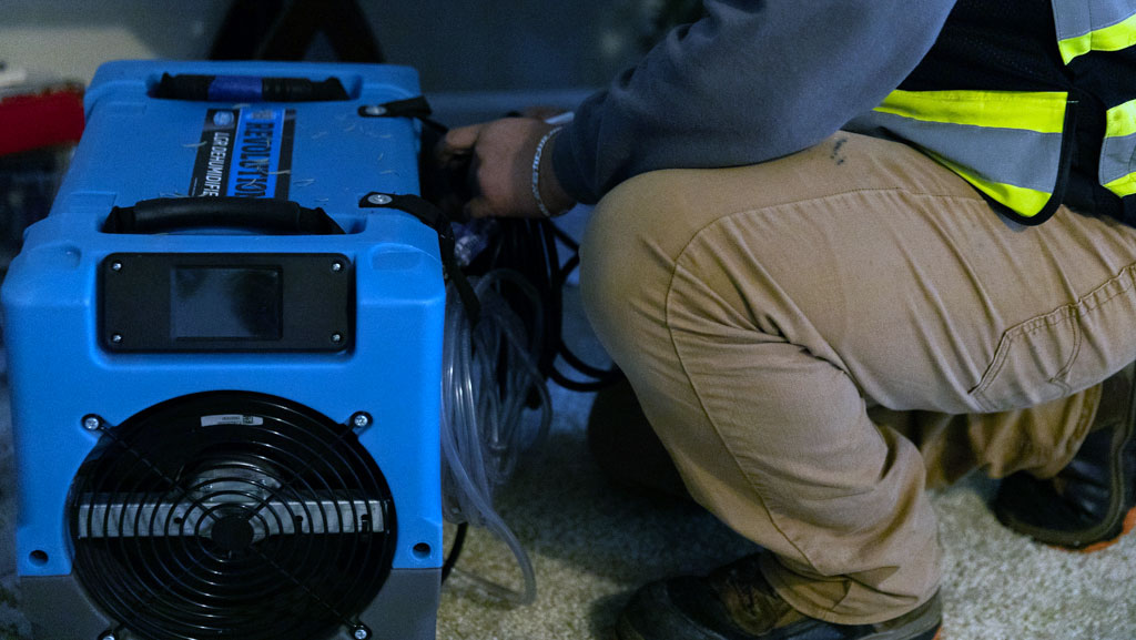 CRC worker setting up drying equipment.