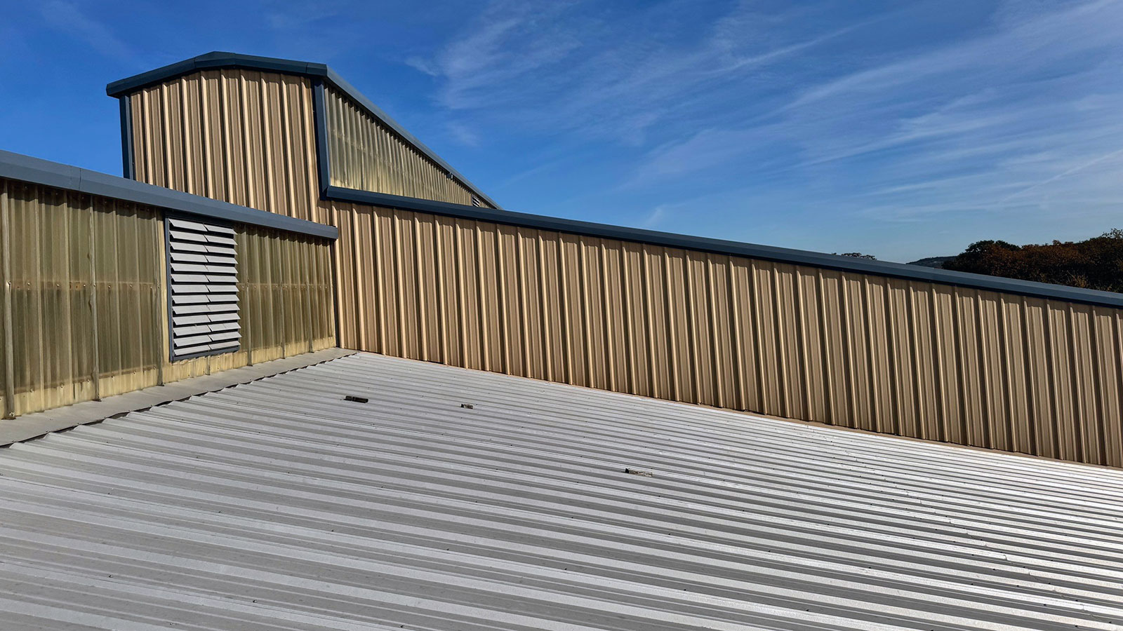Metal roof on a warehouse in DFW with hail damage.