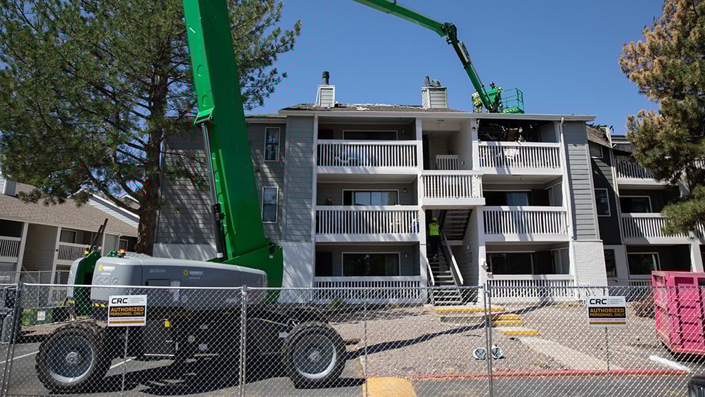 CRC crews inspecting the roof of an apartment building after a fire.