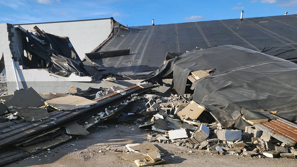 Collapsed roof of warehouse building damaged by a tornado.
