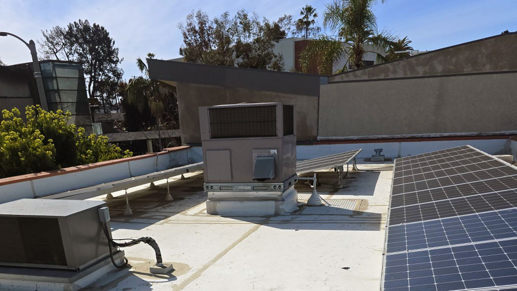 Commercial roof with HVAC unit and solar panel in LA.