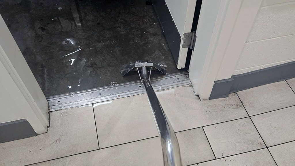 Vacuum removing water from flooded commercial space in LA.