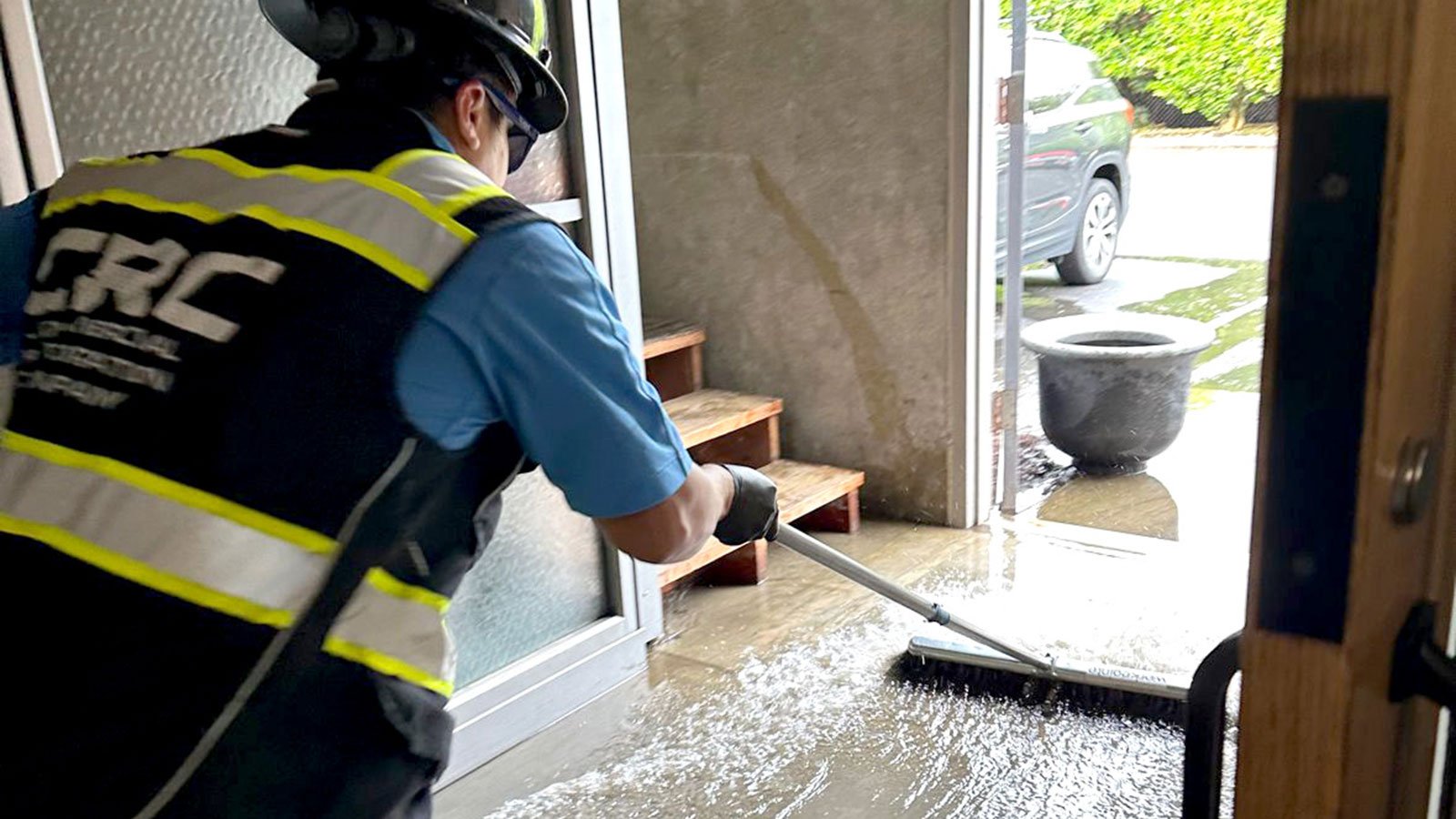 CRC team member pushing water out of warehouse building